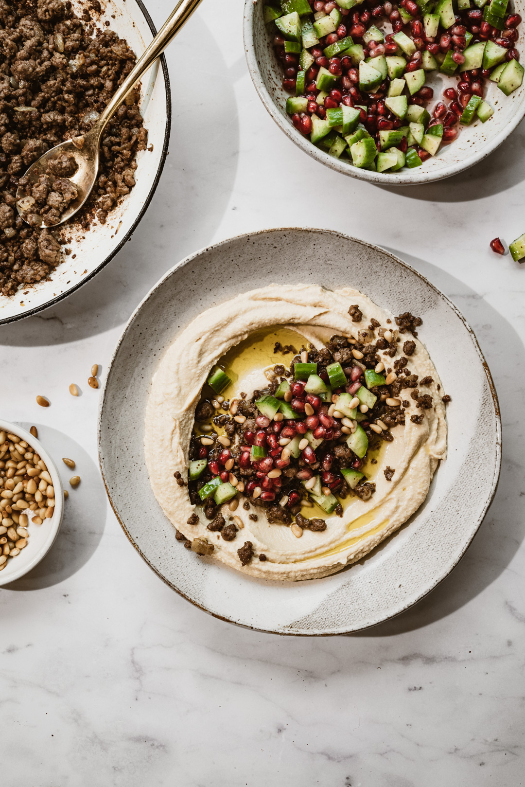 Topped off with a refreshing chopped cucumber and pomegranate salad, we could eat this hummus with vegan spiced meat every day.