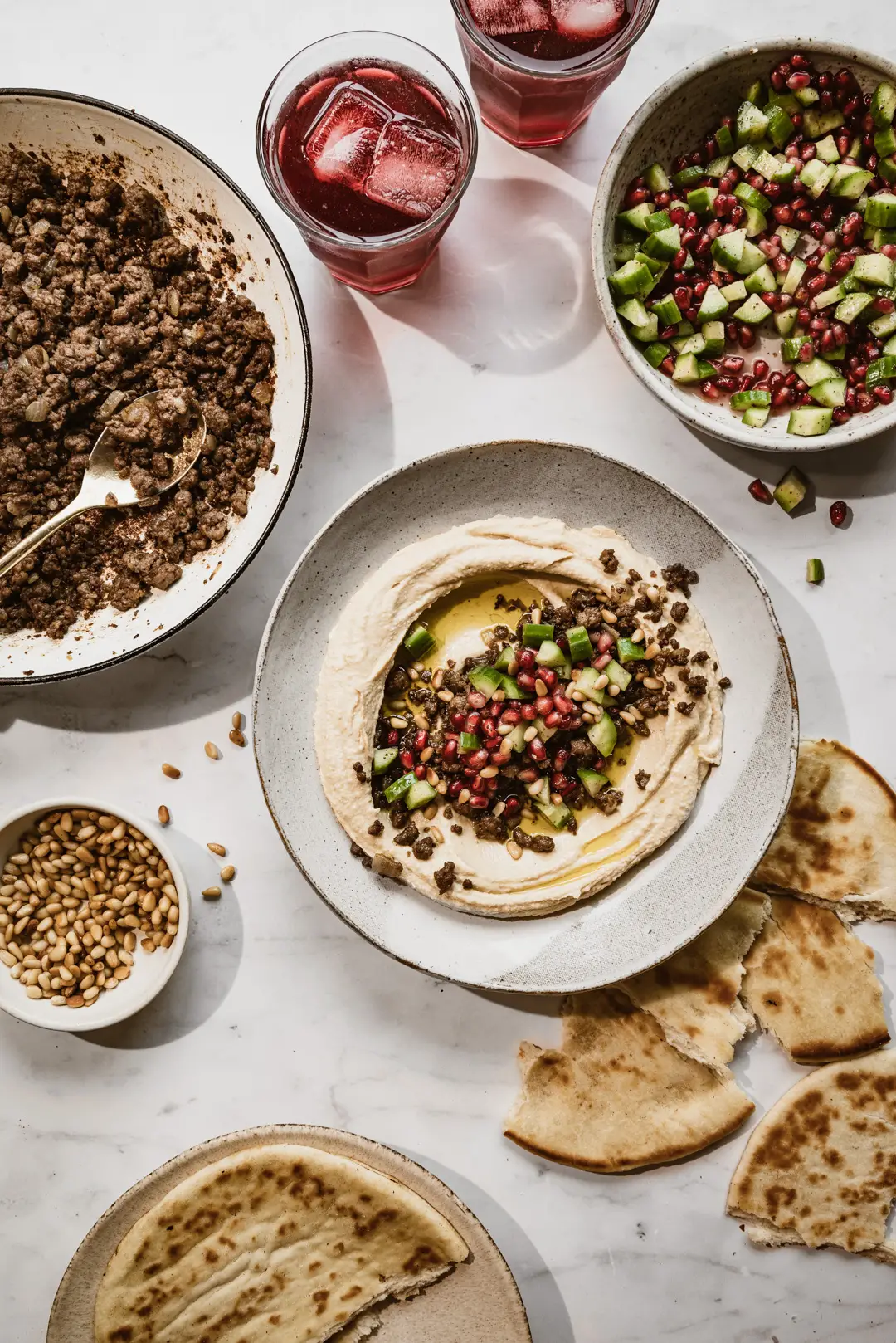 Topped off with a refreshing chopped cucumber and pomegranate salad, we could eat this hummus with vegan spiced meat every day.